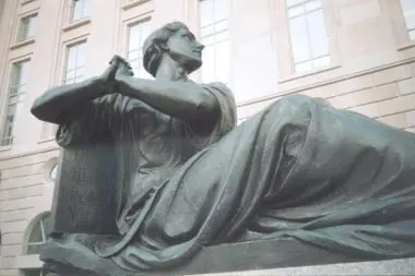 A statue of a woman sitting on the ground.